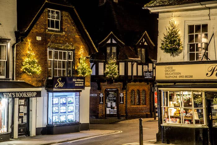 lit christmas trees attached to shops